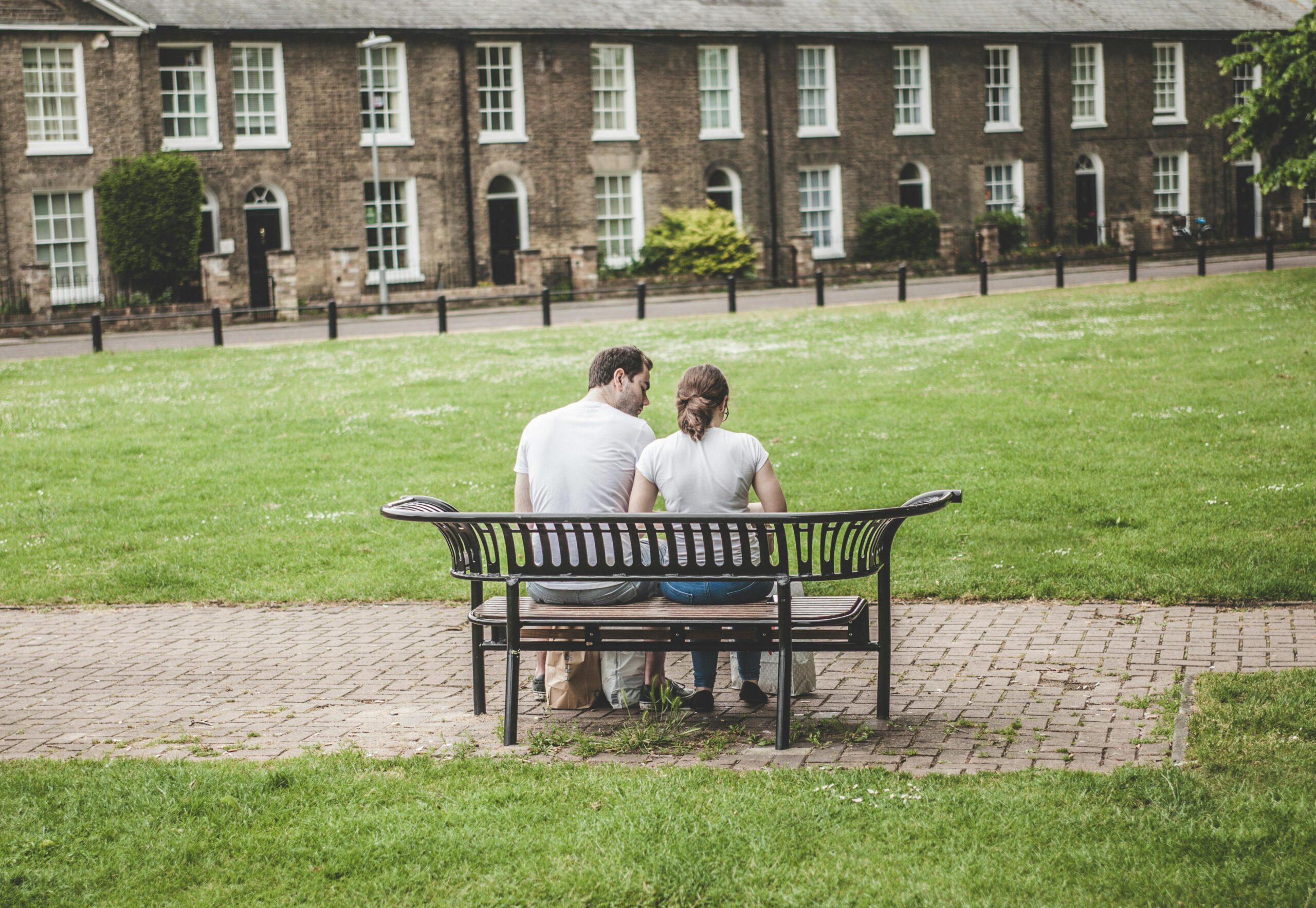 Two people sitting on a bench representing support and connection in addiction recovery and recovery coaching in Charlotte
